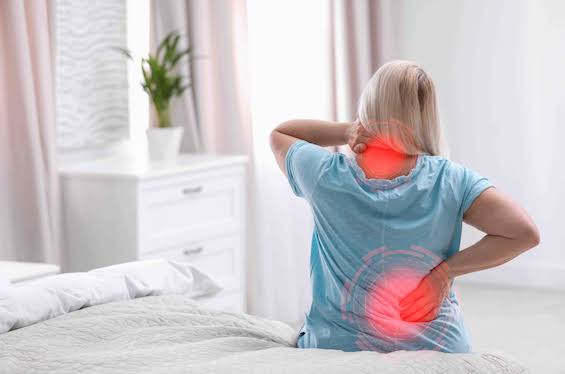 Person sitting at a desk, a common cause of back and hip tension